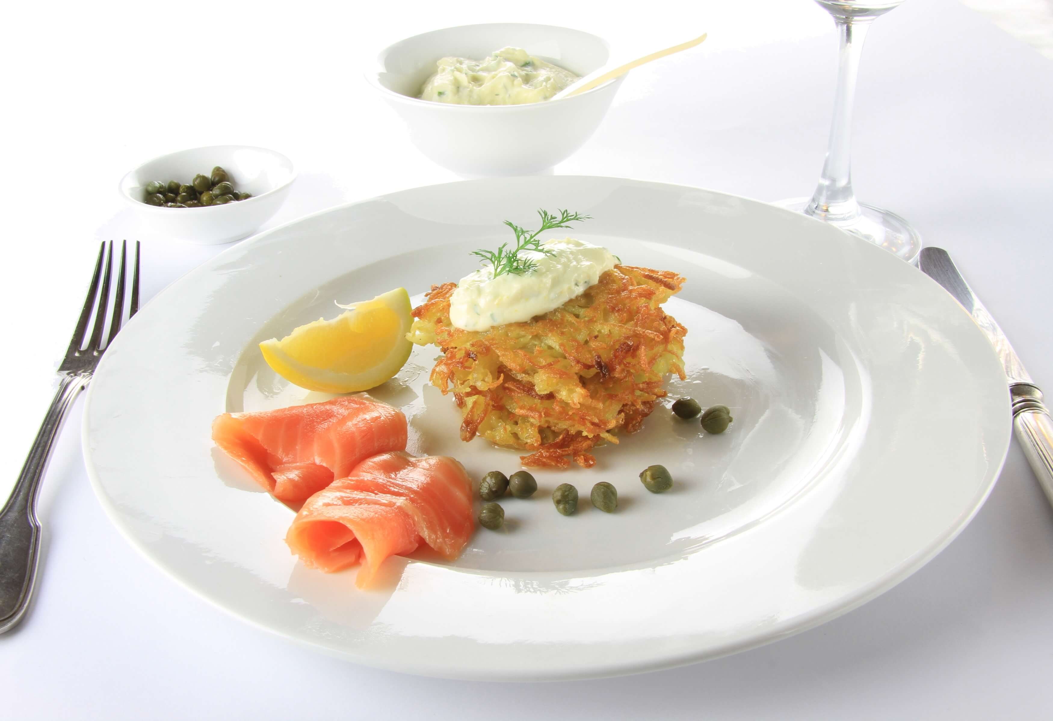 A full plate of served fresh salmon fish with dressing and lemon. 