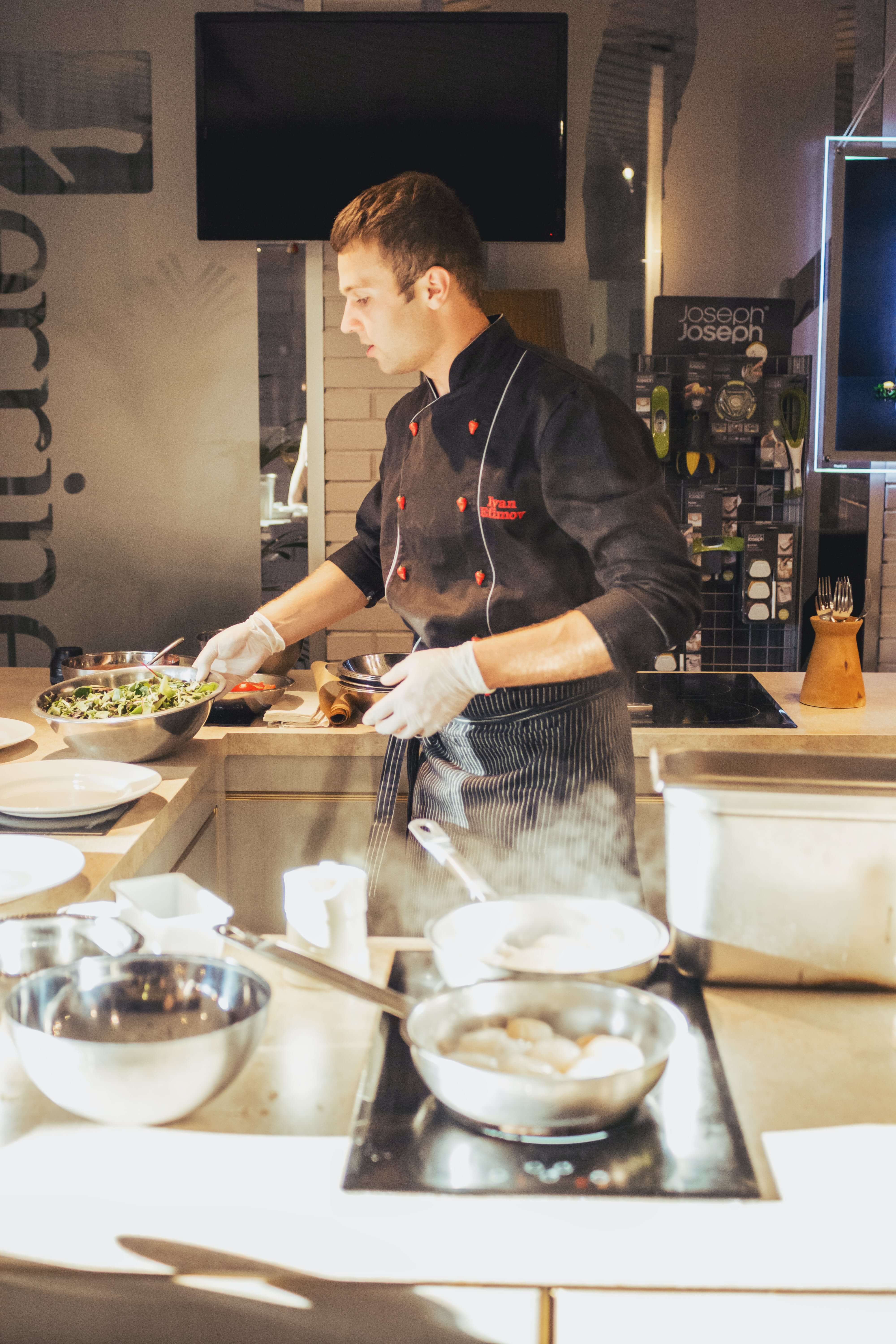 A man in a chef costume cooking in the kitchen.