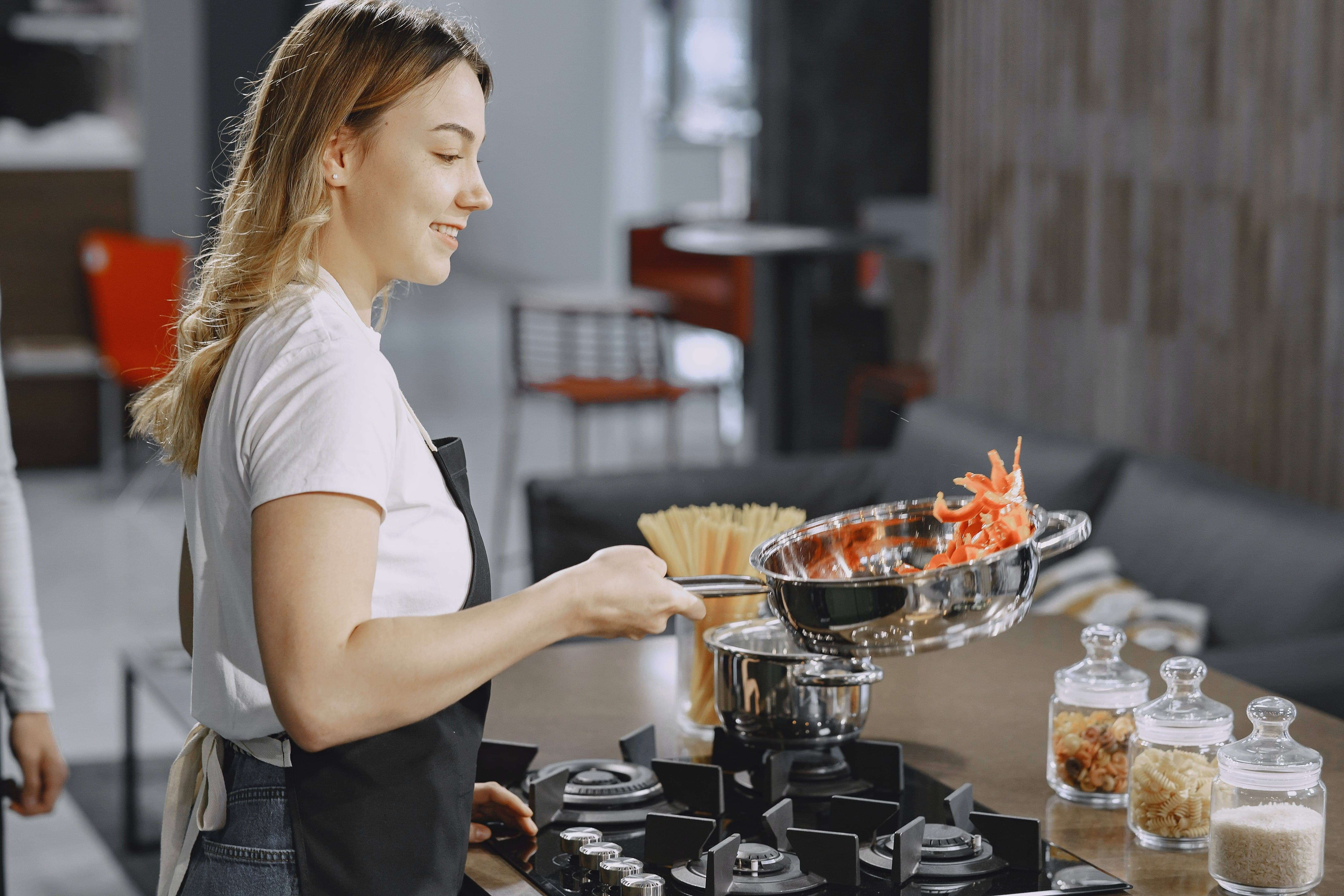 A lady chef in the kitchen washing vegetables.