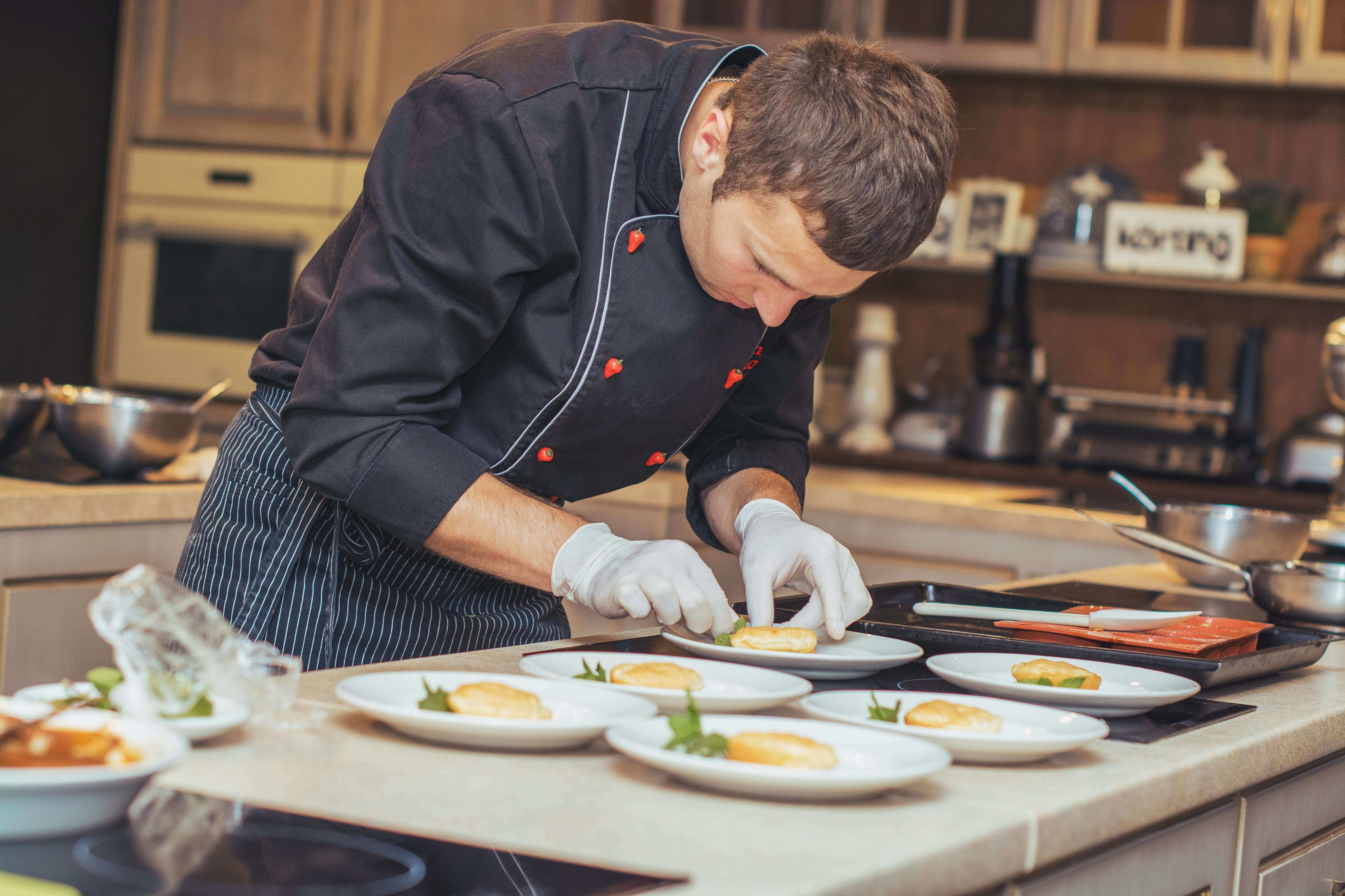 A chef portioning dishes gently.